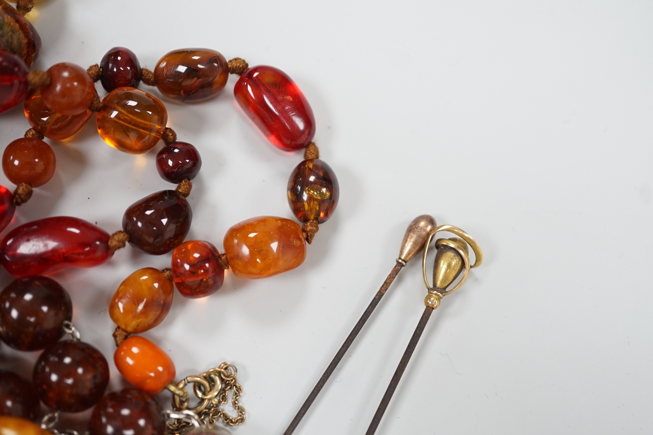 An early 20th century 9ct gold mounted hat pin by Charles Horner, 16cm one other 9ct mounted hat pin, a Margaret Haskell brooch and bracelet and three other items including amber necklace.